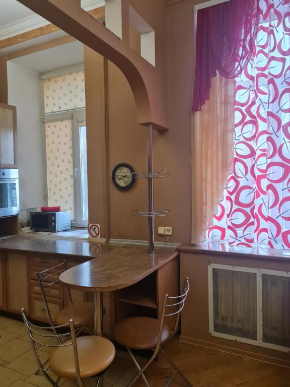 une cuisine avec une table, des chaises et une horloge dans l'établissement Центр, Євгена Коновальця, 3, à Loutsk
