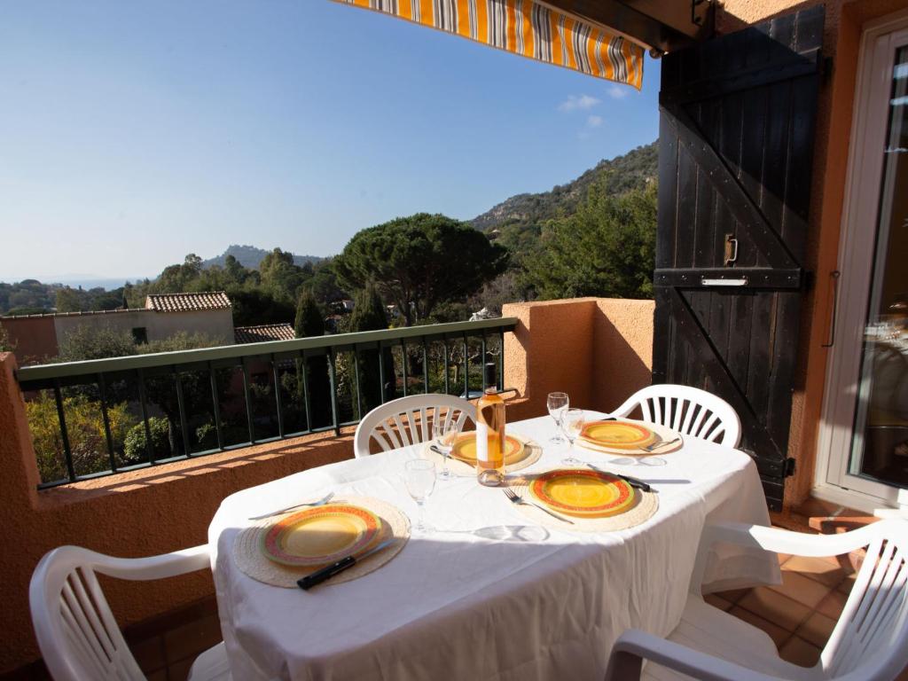 a white table with plates of food on a balcony at Apartment Les Mas de Pramousquier-1 by Interhome in Rayol-Canadel-sur-Mer