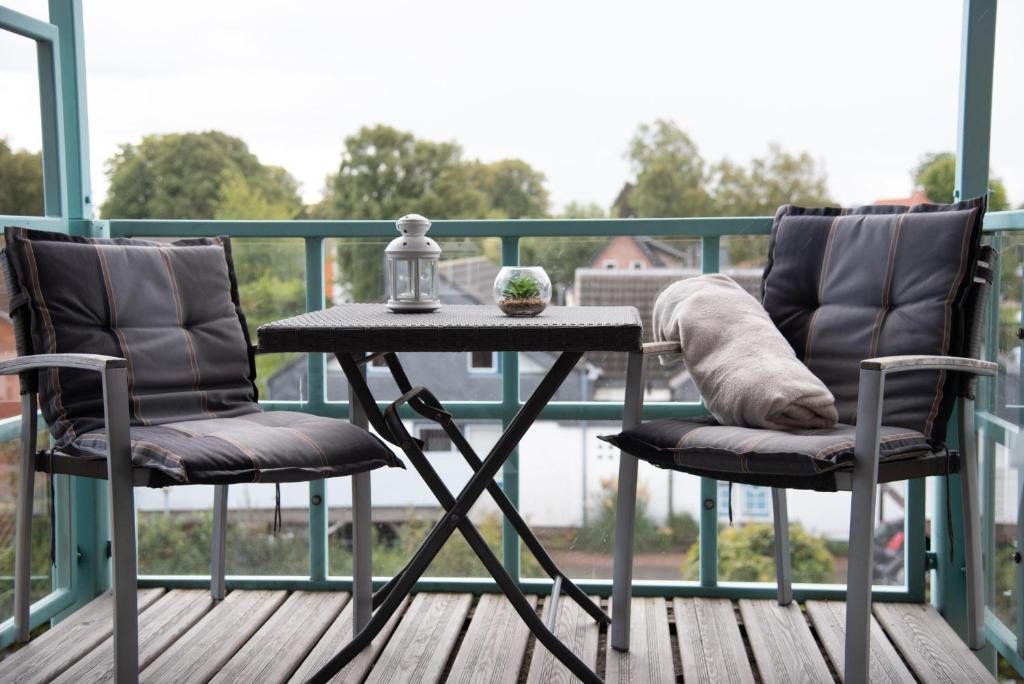 een tafel en 2 stoelen op een balkon bij Steiner Strandappartements Appartement 306 Süd- Landseite in Stein