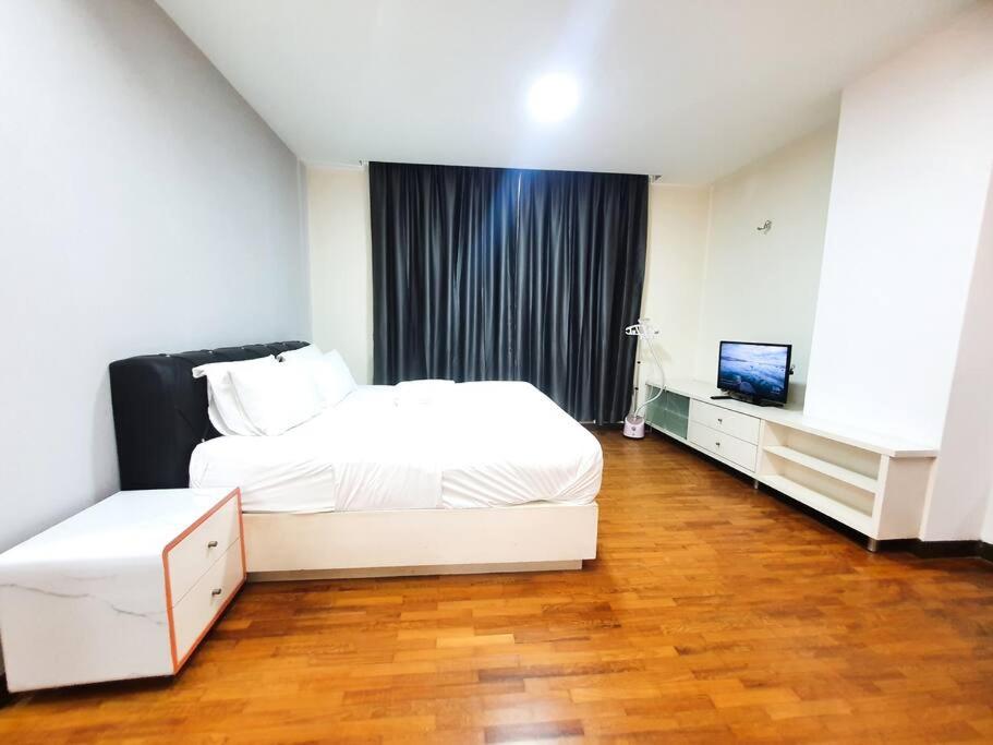 a bedroom with a white bed and a television at [HERITAGE 7] HOMESTAY Studio 4Pax, FREE WIFI in Seri Kembangan