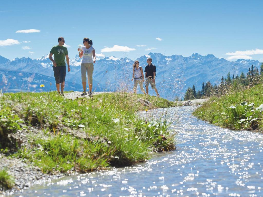 a group of people standing on a hill next to a river at Apartment Jeanne D'Arc Apt- C-28 by Interhome in Crans-Montana