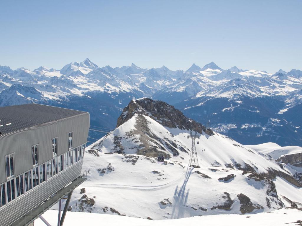 a building on top of a snow covered mountain at Apartment Jeanne D'Arc Apt- C-28 by Interhome in Crans-Montana