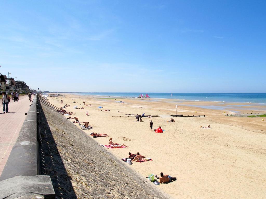 a group of people laying on the beach at Apartment Port Guillaume-6 by Interhome in Cabourg