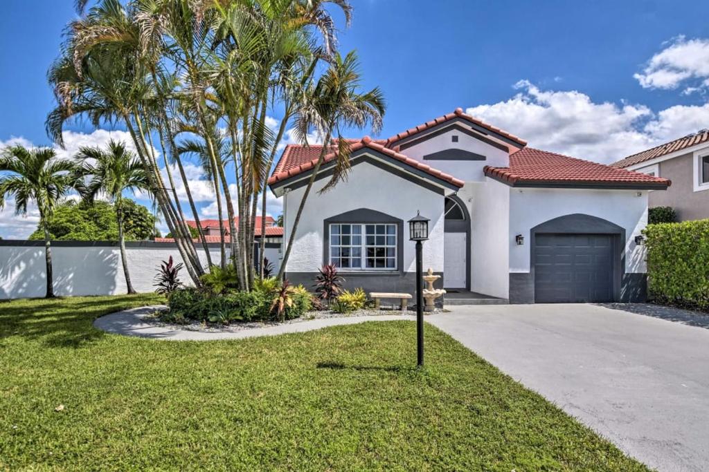 una casa blanca con palmeras y un camino de entrada en Luxury 3BR-2 1/2 Bath w/Patio Entertainment area, en Miami Gardens