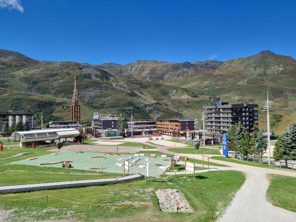 a park in a city with mountains in the background at Apartment Asters 318 Bâtiment A1 by Interhome in Les Menuires