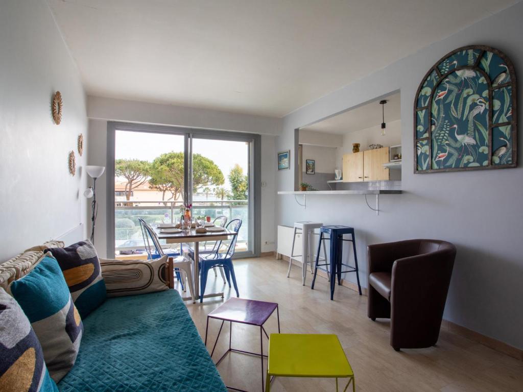 a living room with a couch and a table with chairs at Apartment La Pinède-2 by Interhome in Puits