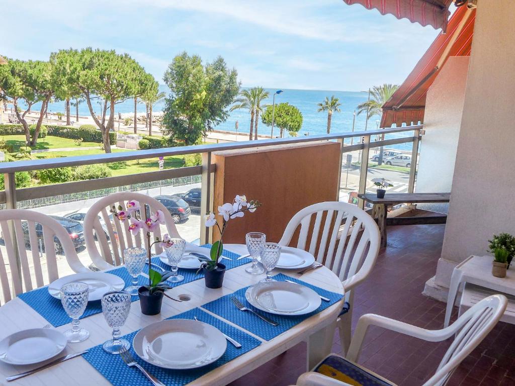 a table with chairs and a table with a view of the ocean at Apartment La Pinède-1 by Interhome in Cagnes-sur-Mer