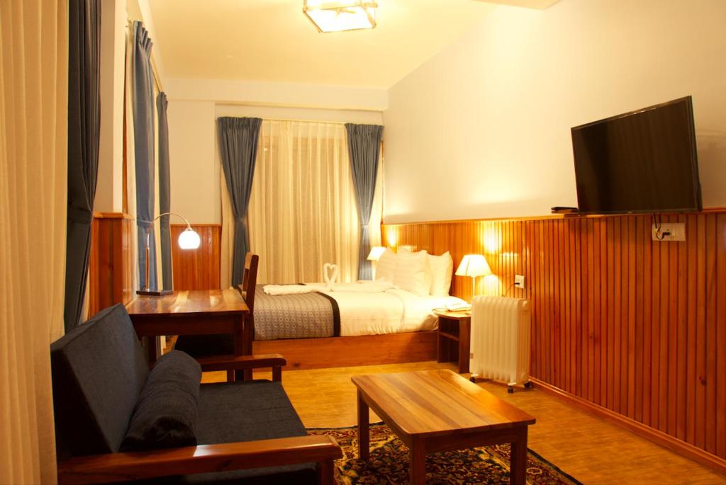 a hotel room with a bed and a television at Tshang Tshang Villa in Paro