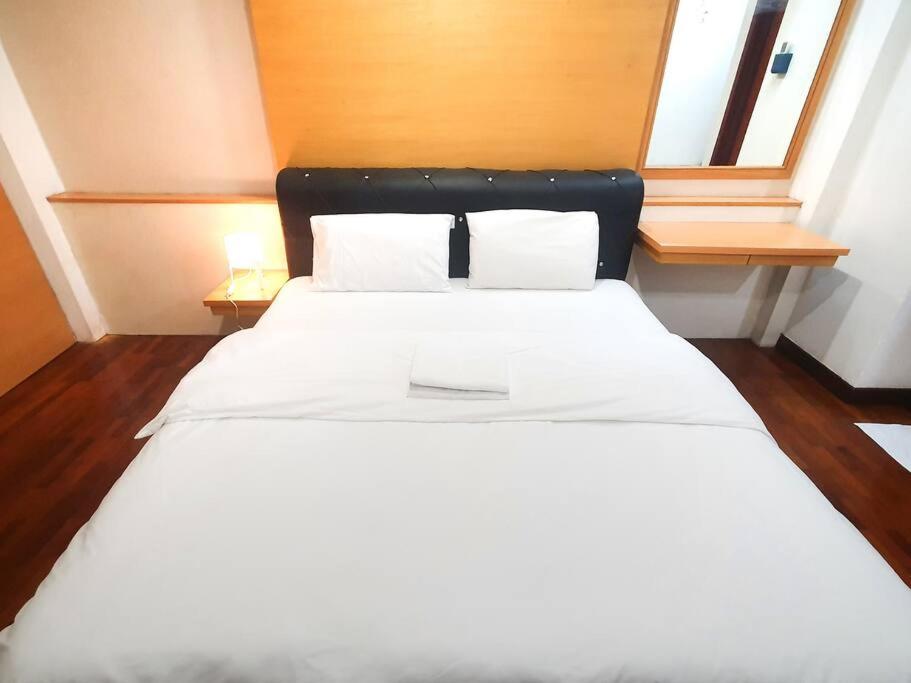 a bedroom with two beds with white sheets and two windows at [HERITAGE 9] HOMESTAY Studio 4Pax, FREE WIFI in Seri Kembangan