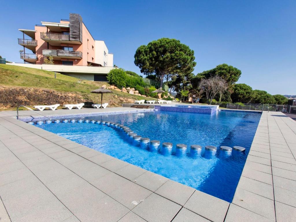 a swimming pool in front of a building at Apartment Jardins Sa Boadella by Interhome in Lloret de Mar