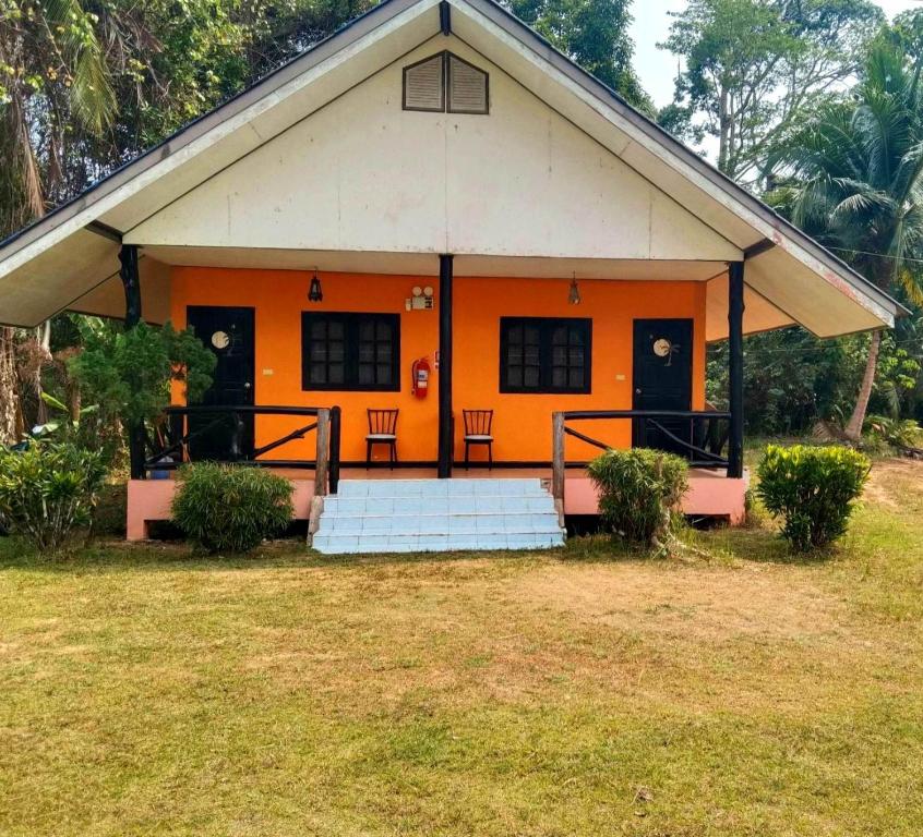 una casa naranja con dos sillas en un patio en Diamond hill salak phet en Ko Chang