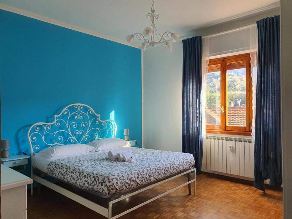 una camera da letto con un letto con una parete blu di Blue Daisy Apartment a Rapallo