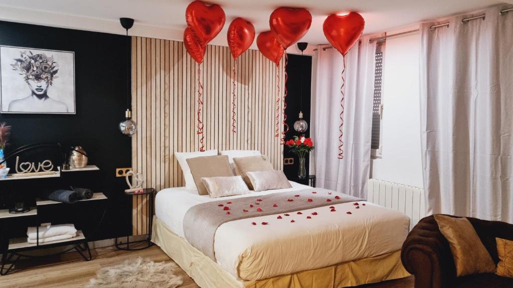 Un dormitorio con una cama con corazones rojos. en Cosy & Jacuzzi 15 mn de Lyon, en Givors