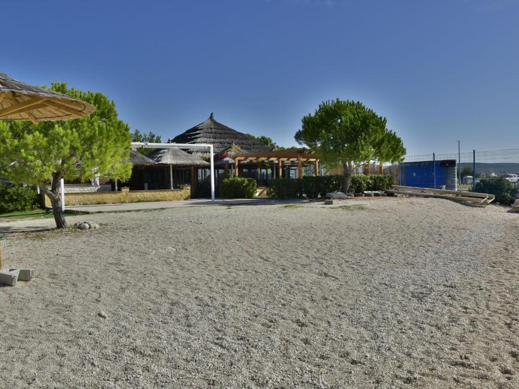 a beach with trees and a house in the background at Apartment Marko by Interhome in Bibinje