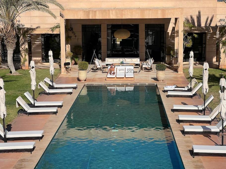 una piscina con tumbonas y una casa en SO Le Palais… make the planet chic again!, en Marrakech
