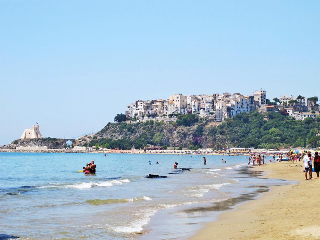 a beach with a bunch of people in the water at Apartment Costa di Kair ed Din-6 by Interhome in Sperlonga