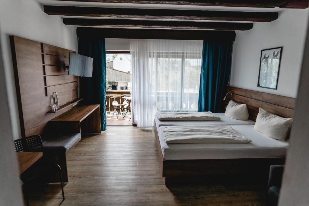 a hotel room with two beds and a balcony at Hotel Reiterhof-Altmühlsee in Gunzenhausen