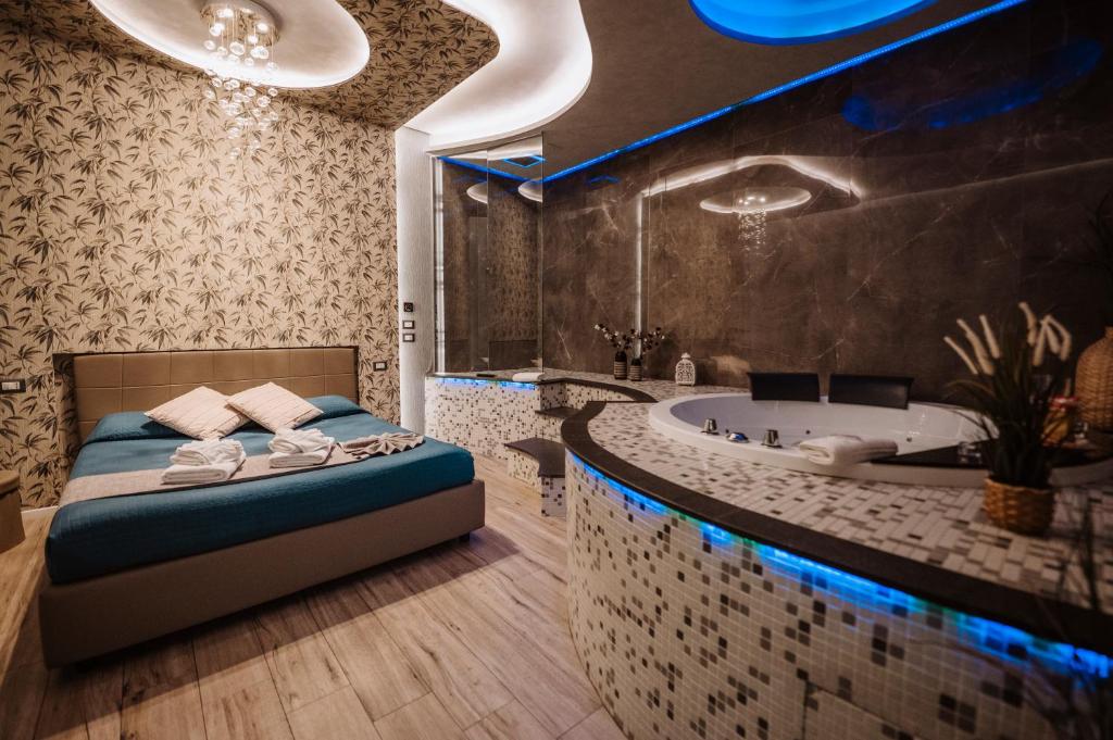 a bathroom with a bed and a tub in it at TH LUXURY SUITE in Giardini Naxos