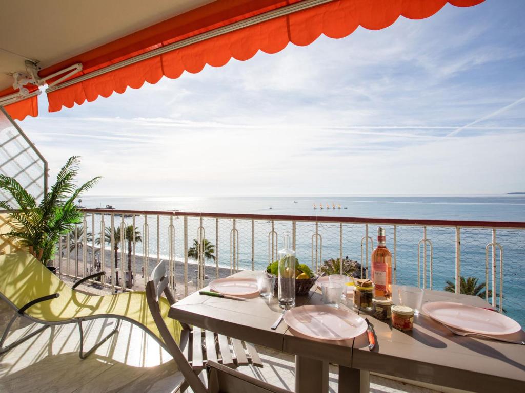 a table on a balcony with a view of the ocean at Apartment L'Angelina-1 by Interhome in Cros-de-Cagnes