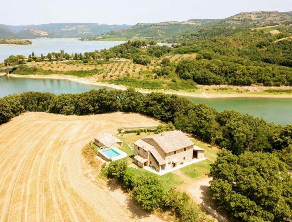 een luchtzicht van een huis naast een veld bij Casale on the lake with sauna and saltwater swimming pool in Baschi