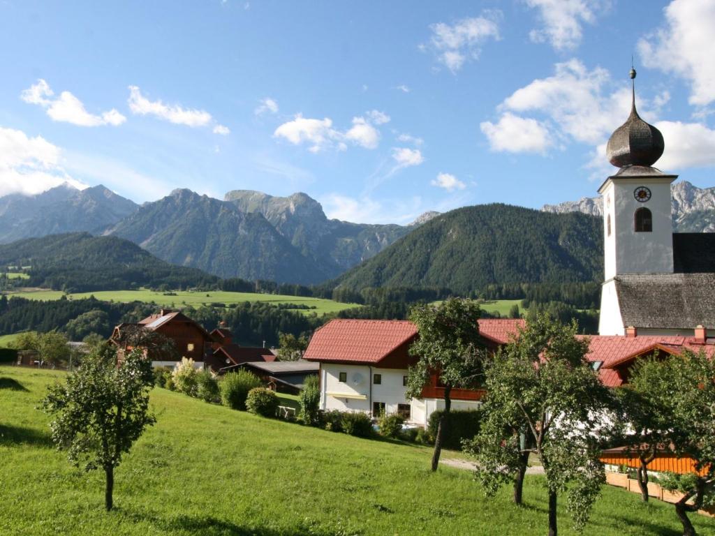 a church on a hill with mountains in the background at Apartment Poldi by Interhome in Haus im Ennstal