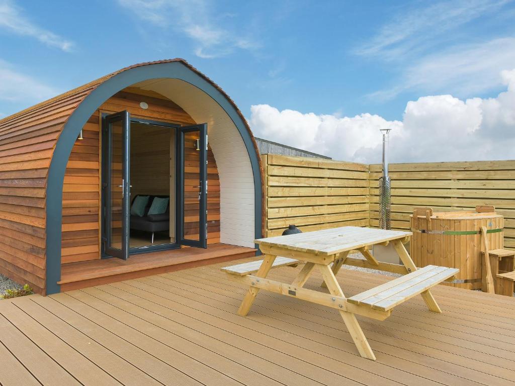 a wooden deck with a picnic table and a tent at Sun Rise in Penzance