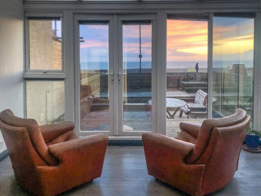 two chairs in a living room with a view of the ocean at Sunset Beach House By Air Premier in Seaford