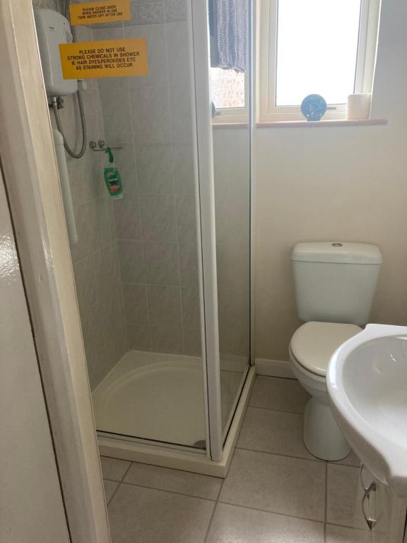 a bathroom with a shower and a toilet and a sink at Happy Holiday apartments in Mablethorpe