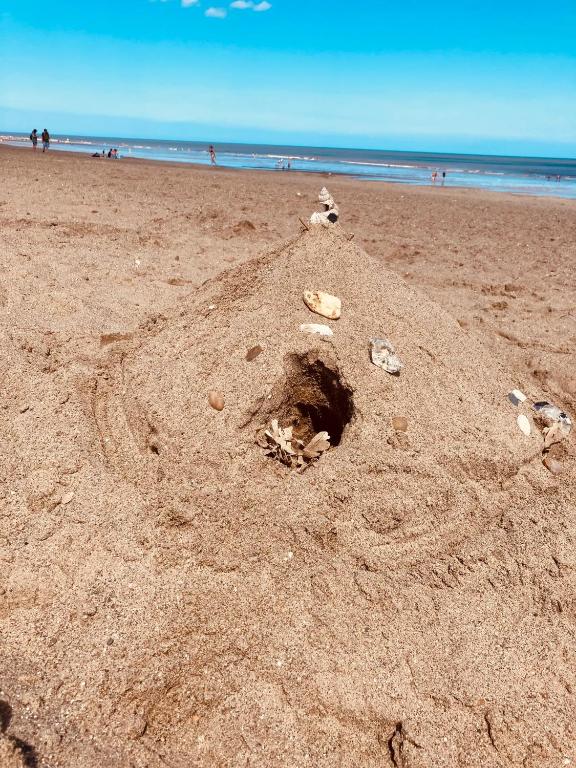 a sand castle on a beach with the ocean in the background at Happy Holiday apartments in Mablethorpe
