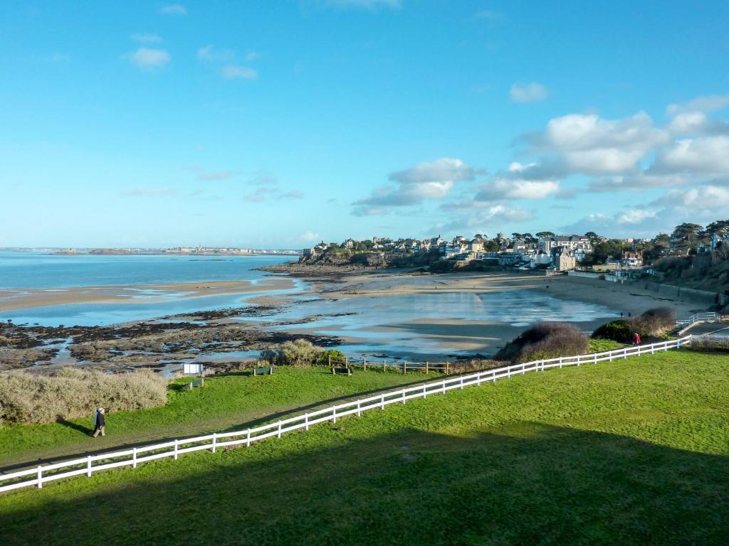 a view of a beach with a fence and the ocean at Studio La Garde by Interhome in Dinard