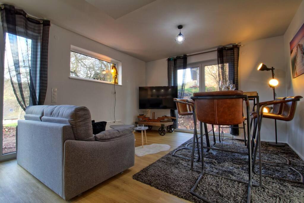 un soggiorno con divano e tavolo di Hohwarth - Le Contemporain - Logement 6 personnes a Saint-Pierre-Bois