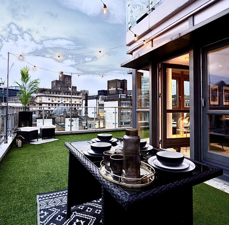 een tafel op een balkon met uitzicht op de stad bij Penthouse Noir - Wyndale Living - Central BHam 2BR in Birmingham
