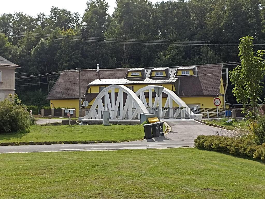 a white bridge in front of a building at Penzion U Halířů in Mladé Buky