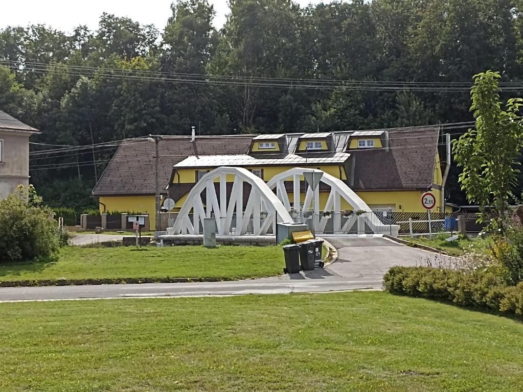 een witte brug voor een gebouw bij Penzion U Halířů in Mladé Buky