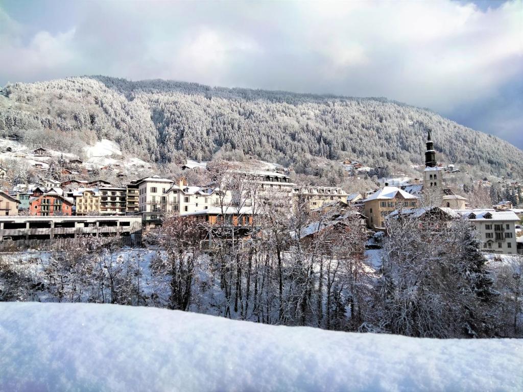 a town covered in snow in front of a mountain at Apartment Domaine de Crespin-3 by Interhome in Saint-Gervais-les-Bains