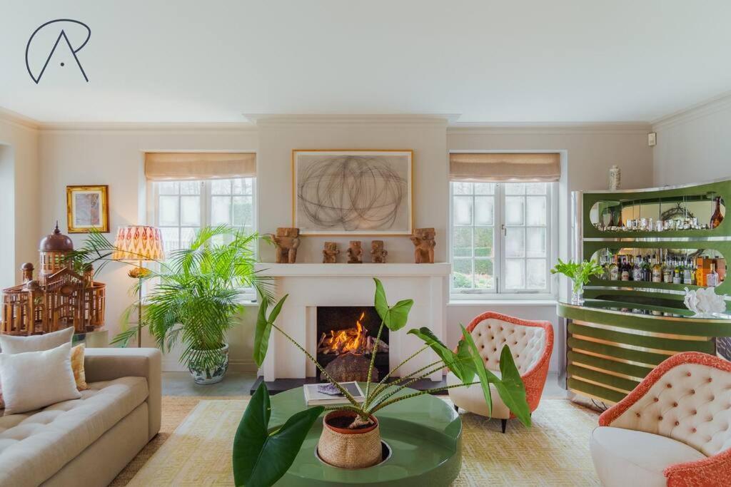 a living room with a couch and a fireplace at Luxury Rural Family Getaway with Tennis Court in Buckinghamshire