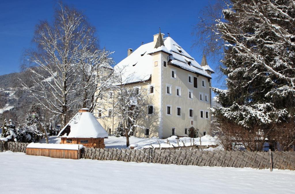 un gran edificio blanco con nieve en el techo en Saalhof Castle, en Maishofen