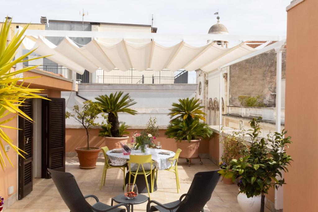 een patio met een tafel, stoelen en planten bij San Colin casa vacanze in Conversano