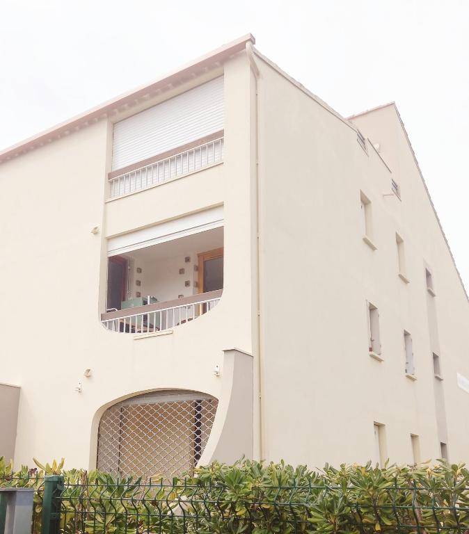 - un bâtiment blanc avec une grande fenêtre dans l'établissement Les Sables d'Or, à Le Castellas