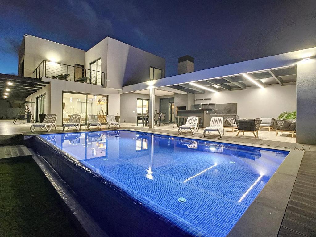 a large swimming pool in the middle of a house at Villa de la Ponte by Atlantic Holiday in Arco da Calheta