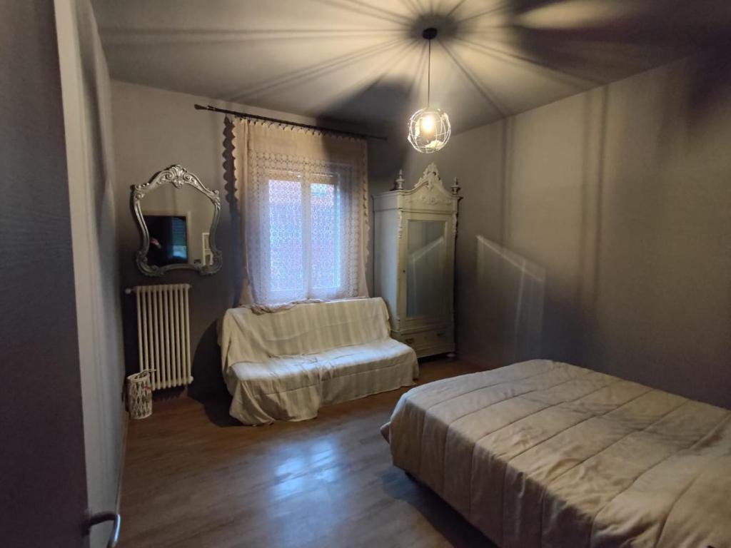 1 Schlafzimmer mit 2 Betten und einem Spiegel in der Unterkunft HomeStory 2 via Idice 72 Pizzano BO in Casa Canovetta