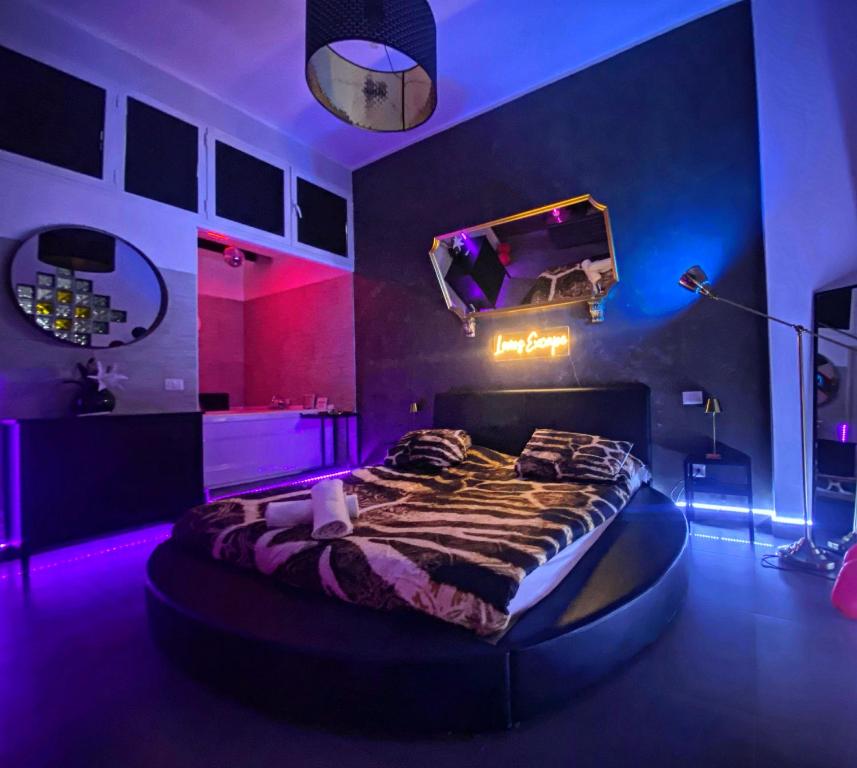 ein Schlafzimmer mit einem Bett in einem Zimmer mit lila Lichtern in der Unterkunft Lovers Excape Roma - Adults Only in Rom