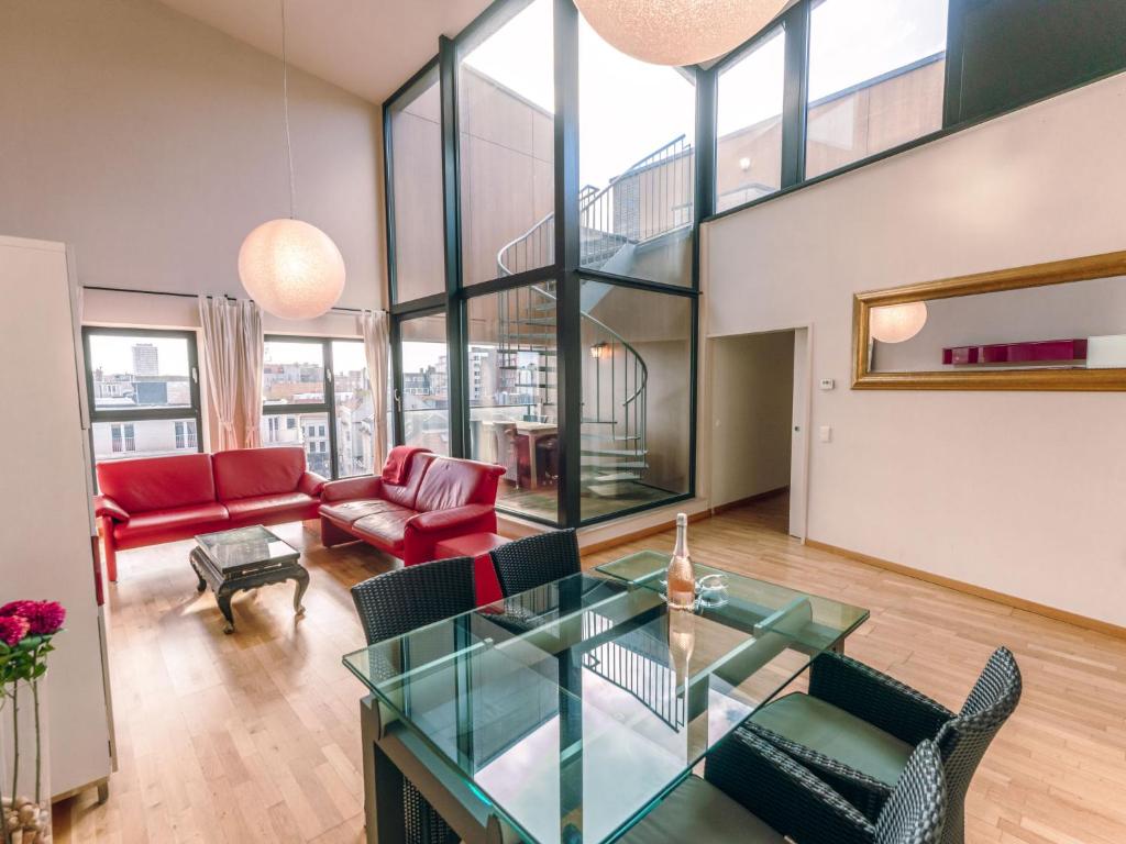 un soggiorno con tavolo e sedie in vetro di Apartment Rooftop Breeze by Interhome a Ostenda