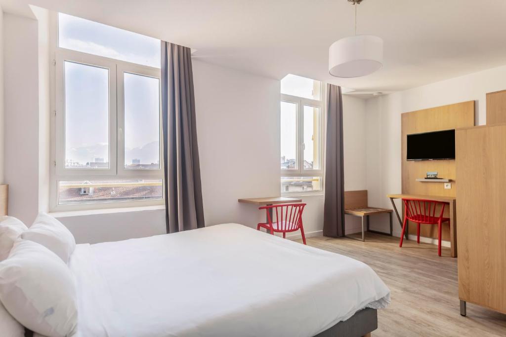 Una habitación de hotel con una cama, una mesa y sillas. en Residhotel Le Central'Gare, en Grenoble