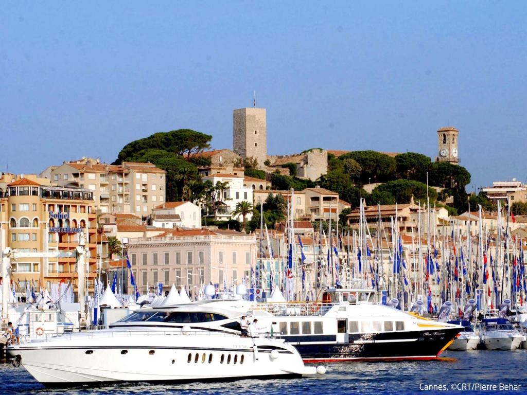 two boats are docked in a harbor with a city at Apartment Les Pins D&#39;Alep by Interhome in Le Cannet