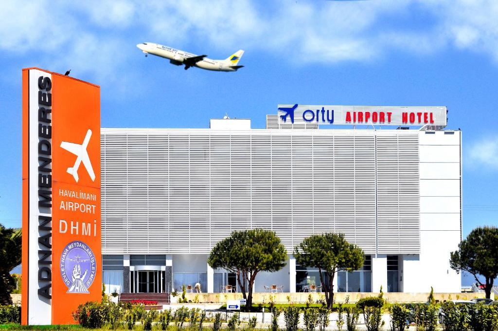 an airplane is flying over a building with an old airport at Orty Airport Hotel in İzmir