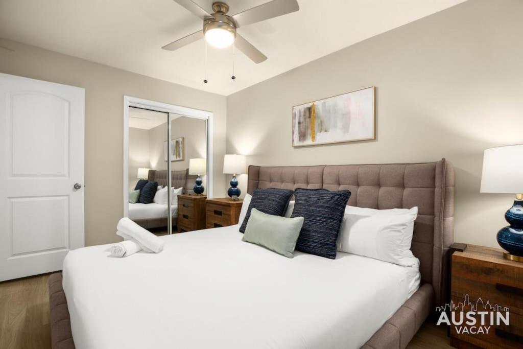 a bedroom with a large white bed with blue pillows at Remodeled Apt w Gated Community and In-Unit Laundry in Austin