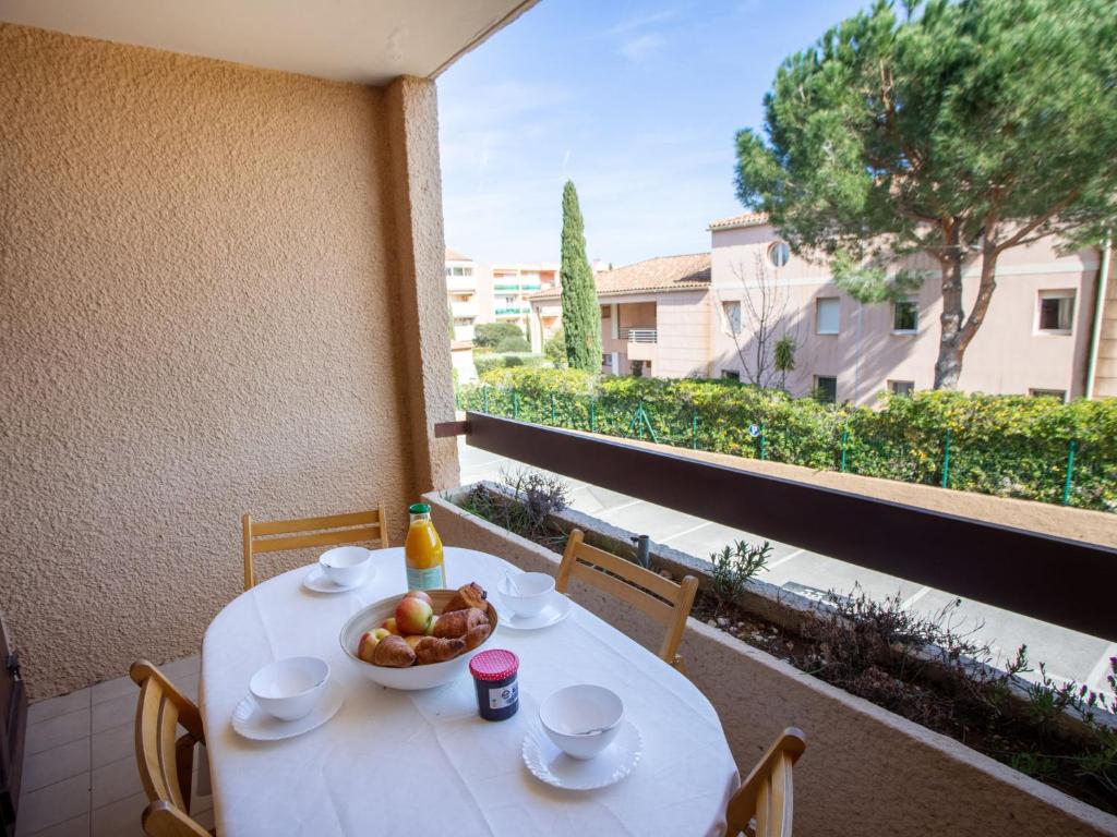 - une table blanche avec un bol de fruits sur le balcon dans l'établissement Studio Les Mimosas Bleus-2 by Interhome, à Bormes-les-Mimosas