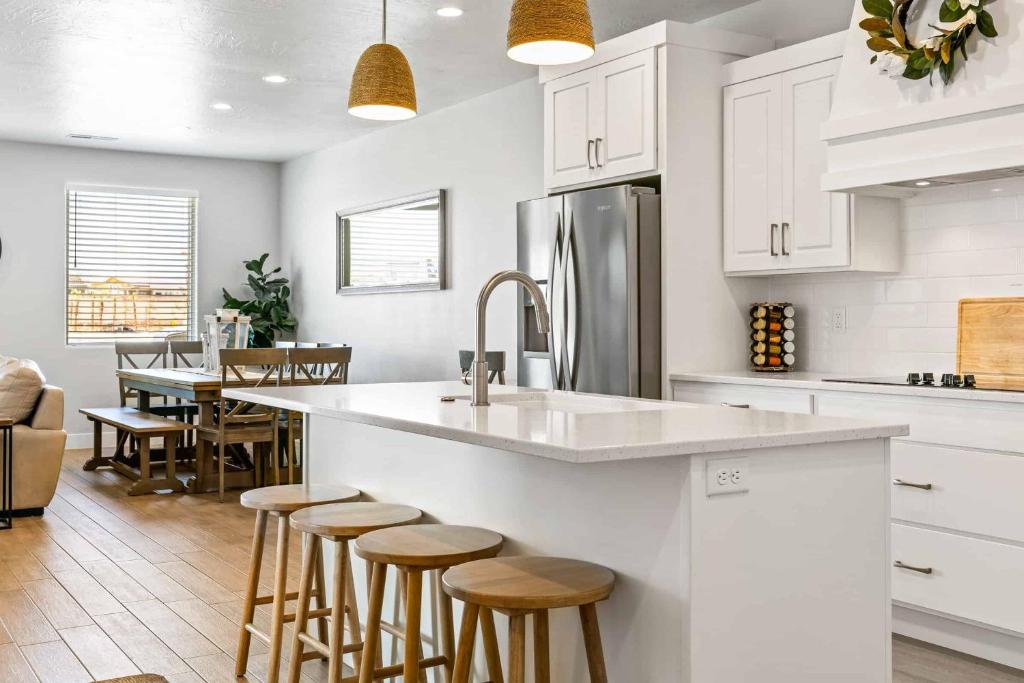 a kitchen with white cabinets and a kitchen island with bar stools at The Pearl at Desert Shores townhouse in St. George