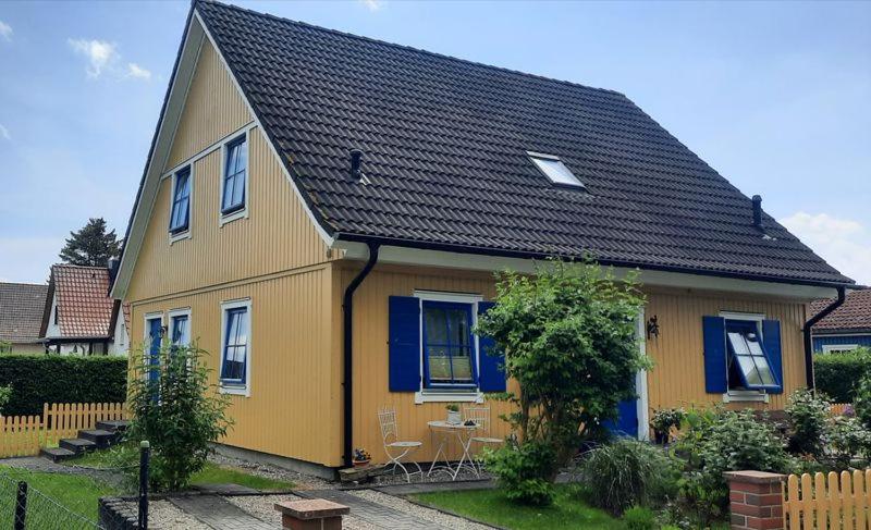 une maison jaune et bleue avec un toit noir dans l'établissement Lindow Rügen, à Putbus